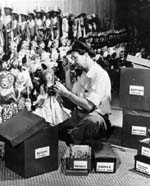Puppeteer Harry Burnett surrounded by puppets and boxes of parts used in making them at Turnabout Theatre workshop